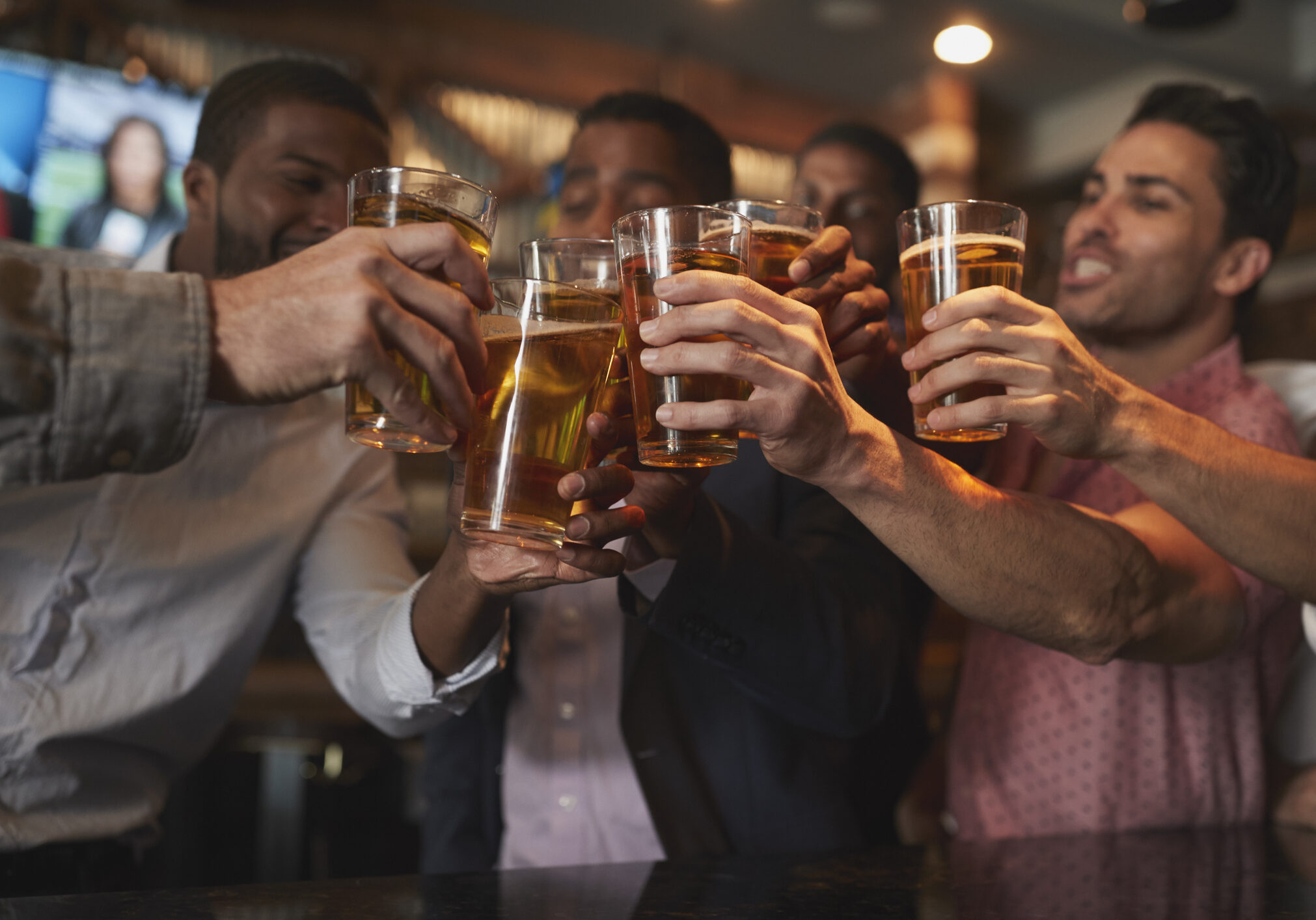 Group Of Male Friends On Night Out For Bachelor Party In Bar Making Toast Together